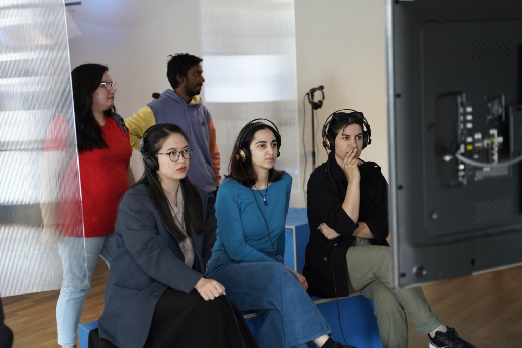 People sitting in the exhibition listening with headphones